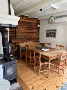 Knivsta布拉卡尔斯托普度假屋的一间带木桌和燃木炉的用餐室
