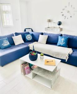 朴次茅斯Seafront Apartment的客厅配有一张蓝色的沙发,配有一张桌子