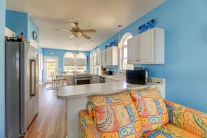 翡翠岛Waterfront Emerald Isle Home with Dock Access!的厨房以及带蓝色墙壁和沙发的客厅。