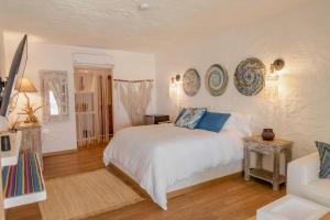 格兰德岛Bora Bora Beach Club & Hotel的卧室配有白色床和蓝色枕头
