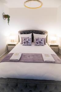 博茨科沃Aquarius Residence Apartament 104的一间卧室配有一张带紫色枕头的大床