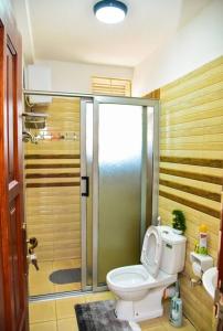 坎帕拉Stylish 3-bedroom condo with a Power-backup, Swimming pool and Gym的浴室配有卫生间和带淋浴的淋浴。