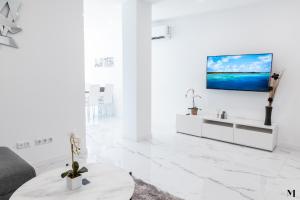 圣胡安海滩Aqua Vista Playa San Juan的白色的客厅,墙上配有电视