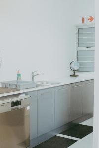 斯瓦科普蒙德Oceana View的厨房配有白色橱柜和水槽