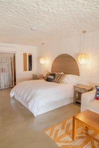 格兰德岛Bora Bora Beach Club & Hotel的卧室配有一张白色的大床和一张沙发。