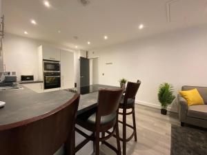 利物浦Modern 3 bedroom apartment close to the city centre的厨房以及带桌椅的起居室。
