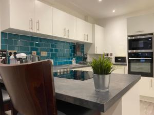 利物浦Modern 3 bedroom apartment close to the city centre的厨房配有白色橱柜和蓝色瓷砖