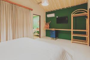 Coqueiro SêcoPousada Vilagoa的一间卧室设有一张床和绿色的墙壁