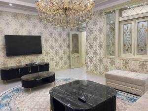 塔什干Luxury huge Apartment的一间带电视和吊灯的客厅