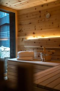 安泰塞尔瓦·迪·梅佐Amus Chalets Dolomites - Luxury Chalets South Tyrol的一个带木墙和一篮毛巾的桑拿浴室
