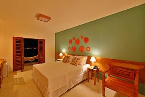 圣米格尔-杜斯米拉格里斯Angá Beach Hotel的卧室配有白色的床和绿色的墙壁