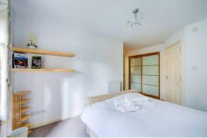 爱丁堡Lovely 2 BDR apartment in Dalry / near Haymarket的卧室配有白色的床和书架