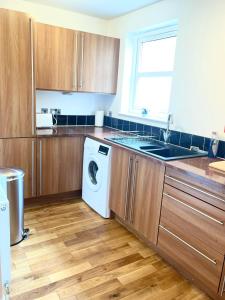因弗内斯Inverness Highland Apartment的厨房配有木制橱柜和洗衣机。