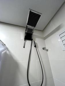 EncantadoApartamento Confortável的带淋浴的浴室,墙上配有笔记本电脑