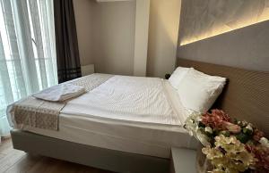 伊斯坦布尔尼康亚港口套房及酒店的一间卧室,配有一张带花瓶的床