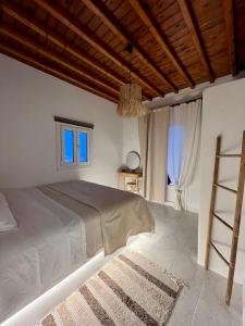圣斯特凡诺斯Lux Mykonos house的一间卧室设有一张带木制天花板的大床