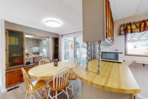 ChristinaLazy Dayz Cottage的厨房以及带木桌和椅子的用餐室。