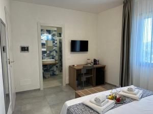 法维尼亚纳Calafato Guest House的客房设有床、书桌和电视。