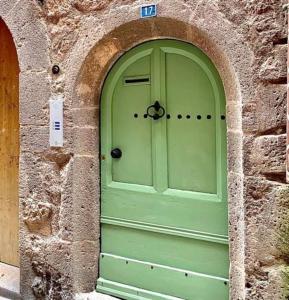 阿格德Rooftop Agde的石头建筑中带拱门的绿色门