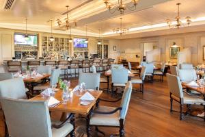 希尔顿黑德岛海港镇度假村和俱乐部的一间带木桌椅的餐厅和一间酒吧