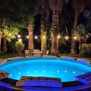 马斯卡卢恰Orlando, quadrupla con bagno privato的一个带桌椅的大型游泳池