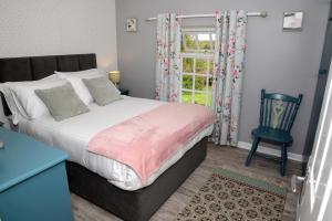 CloverhillCloverhill Gate Lodge的卧室配有床、椅子和窗户。