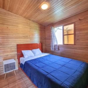 巴兰卡Apart Hotel El Paraíso de Barranca的一间位于木制客房内的卧室,配有一张蓝色的床