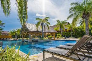 Boca de Río HatoBristol Lake House - Private Pool - King Beds - Next to El Faro Beach Club的一个带2把躺椅的游泳池,棕榈树