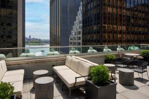 纽约The Wall Street Hotel New York City的阳台配有桌椅,享有城市美景。