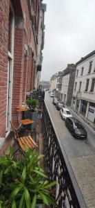 希迈Aux frais de la princesse - Gîte citadin 3 épis的阳台设有长椅和停在街道上的汽车