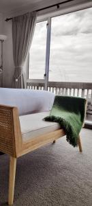 努盖特角Kaka Point Spa Accommodation - Catlins的一间卧室配有一张带绿色枕头的床