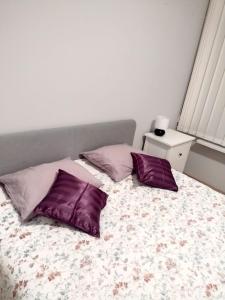 华沙ToTuToTam的卧室配有一张床上的2个紫色枕头