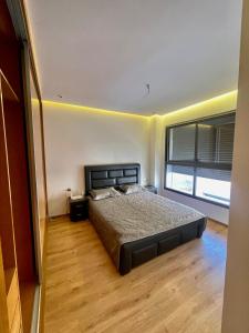 埃尔哈豪拉Harhoura的一间卧室设有一张床和一个大窗户