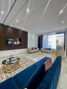 埃尔哈豪拉Harhoura的客厅配有蓝色的沙发和电视