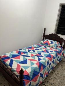 麦德林Pacifica Hostel的一张床上,床上有五颜六色的被子