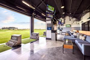 弗赖拉辛Omni PGA Resort Frisco-Dallas的带沙发和电视的俱乐部会所和高尔夫球场
