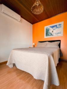 格拉玛多Casa da bela Vista的一间卧室配有一张白色的床和橙色的墙壁