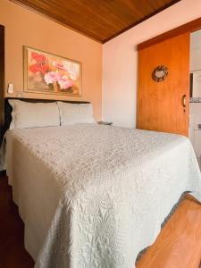 格拉玛多Casa da bela Vista的卧室配有白色的床