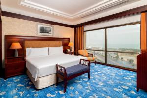 科威特科威特智选假日酒店的酒店客房设有一张床和一个大窗户
