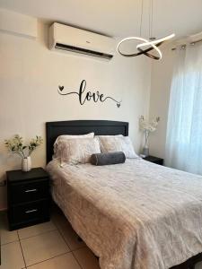 特古西加尔巴Monoambiente Apart-Studio的卧室配有一张挂有爱情标志的床