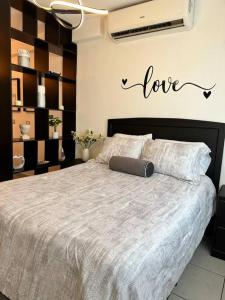 特古西加尔巴Monoambiente Apart-Studio的卧室配有一张挂有爱情标志的床
