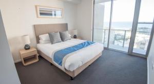 玛志洛木棉活力公寓式酒店的一间卧室设有一张床,享有海景