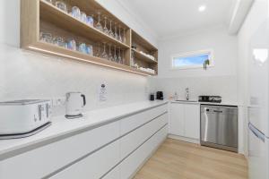 Banksia BeachOsprey Oasis的厨房配有白色橱柜和台面
