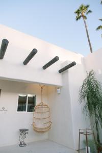 棕榈泉Yara Hotel - Adults Only的白色房子的一侧有鸟笼