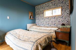 大村市鉢巻山荘的蓝色墙壁客房的两张床