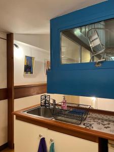 伊夫雷亚La Serra Olivetti的厨房配有水槽和蓝色橱柜