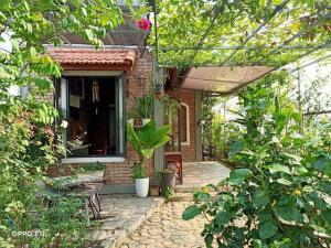 顺化Homestay Mộc Nhi的砖屋,带有庭院和植物