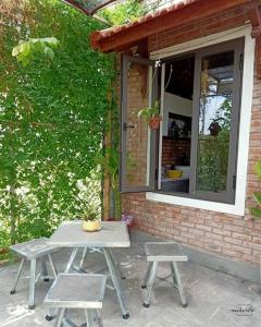 顺化Homestay Mộc Nhi的野餐桌和两把椅子位于房子前面