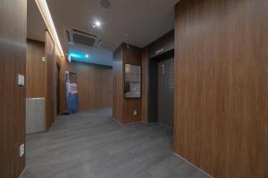 大田Aank Hotel Daejeon Yuseongonsen 1st的走廊设有木镶板,走廊设有门