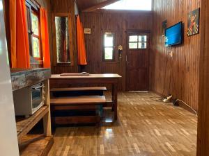 伊瓜苏港Los Bananos - Big Wood Cabin的一间房子里带桌子和电视的房间